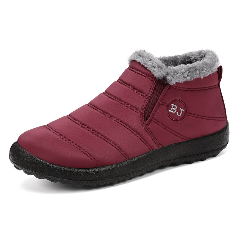 Women's warm winter boots laid flat on snowy surface