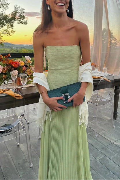 Green pleated maxi dress with flowing fabric detail close-up