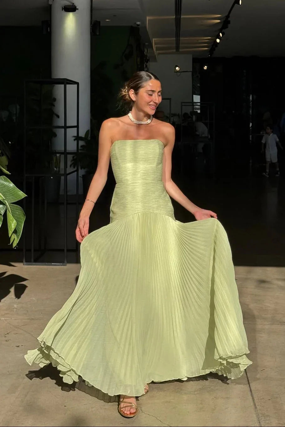 Women's formal green pleated maxi dress back view full-length
