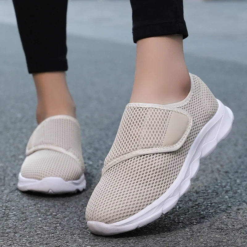 Stravio wide-fit shoe in black displayed at angle showing strap and mesh