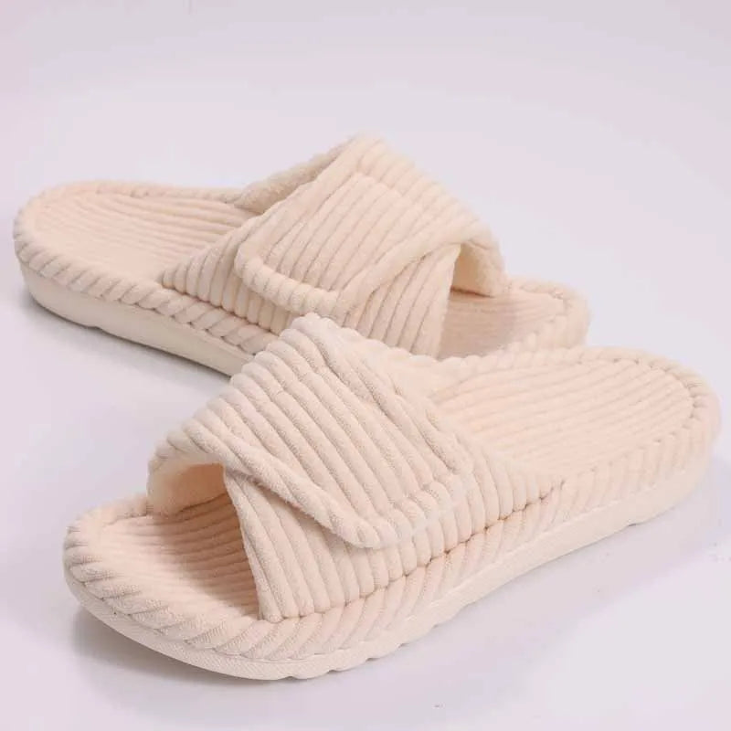 Women wearing open-toe plush house slippers on a bedroom floor