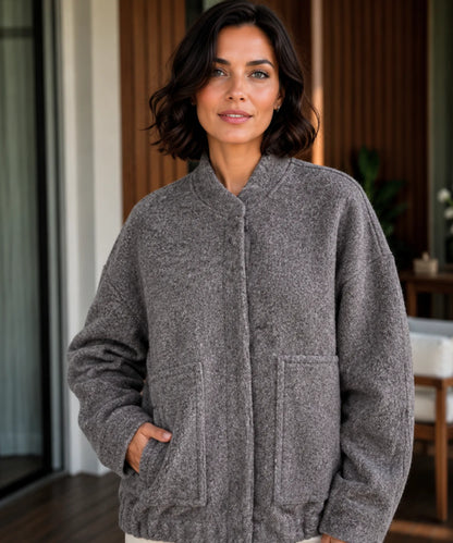 Close-up of bouclé wool texture on women's oversized bomber jacket