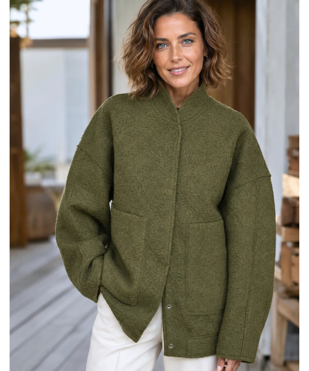 Side pocket detail on camel bouclé bomber jacket, close-up