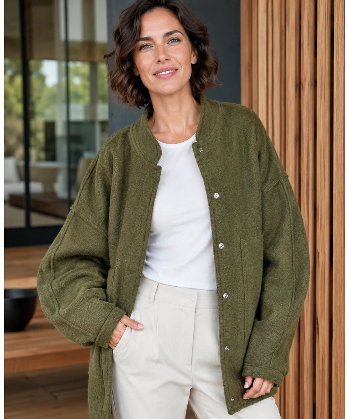 Flat lay of oversized bouclé bomber jacket in yellow on neutral background