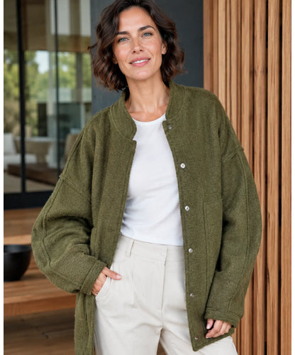Flat lay of oversized bouclé bomber jacket in yellow on neutral background