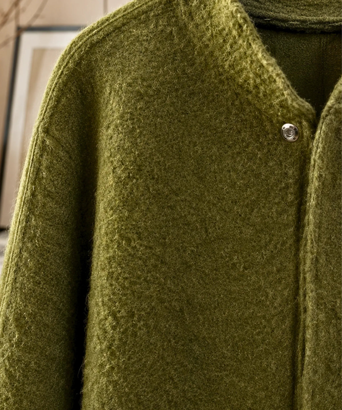 Close-up of bouclé wool fabric texture on white bomber jacket