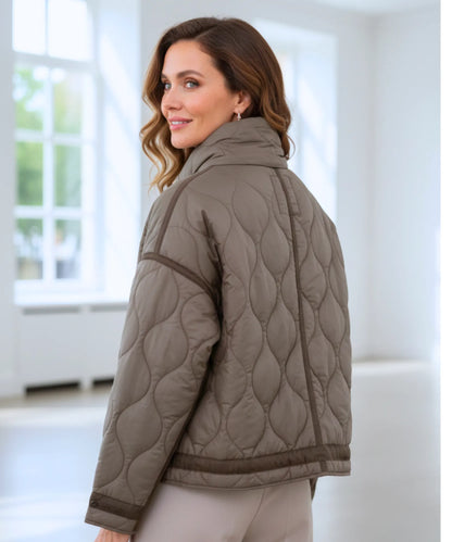 Women's puffer jacket showing adjustable cuffs and side pocket detail